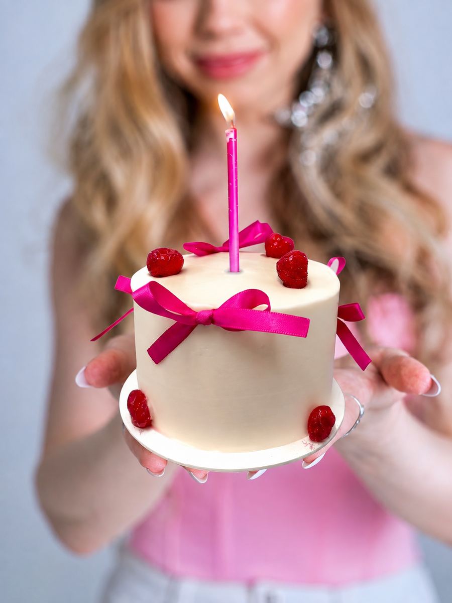 Pastel Rose Crème sostenido con velita rosa encendida